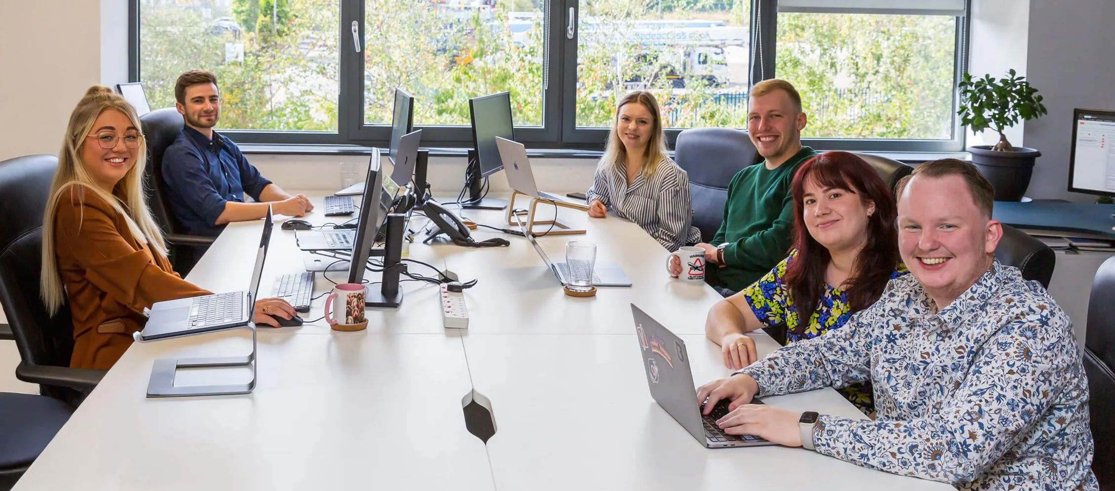 Unbranded Digital Team in the office sitting at a large white desk